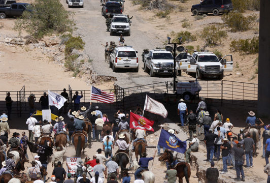 Protesters gather at the Bureau of Land Management's base camp, where cattle that were seized from rancher Cliven Bundy are being held, near Bunkerville, Nevada April 12, 2014. The U.S. Bureau of Land Management on Saturday said it had called off an effort to round up Bundy's herd of cattle that it had said were being illegally grazed in southern Nevada, citing concerns about safety. The conflict between Bundy and U.S. land managers had brought a team of armed federal rangers to Nevada to seize the 1,000 head of cattle.